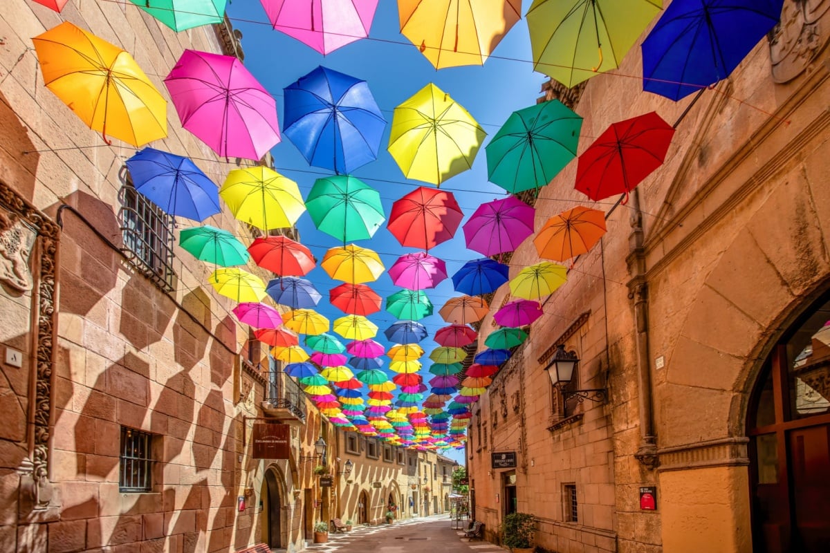 Colorful umbrellas hanging over the street used as decoration in Poble Espanyol in Barcelona